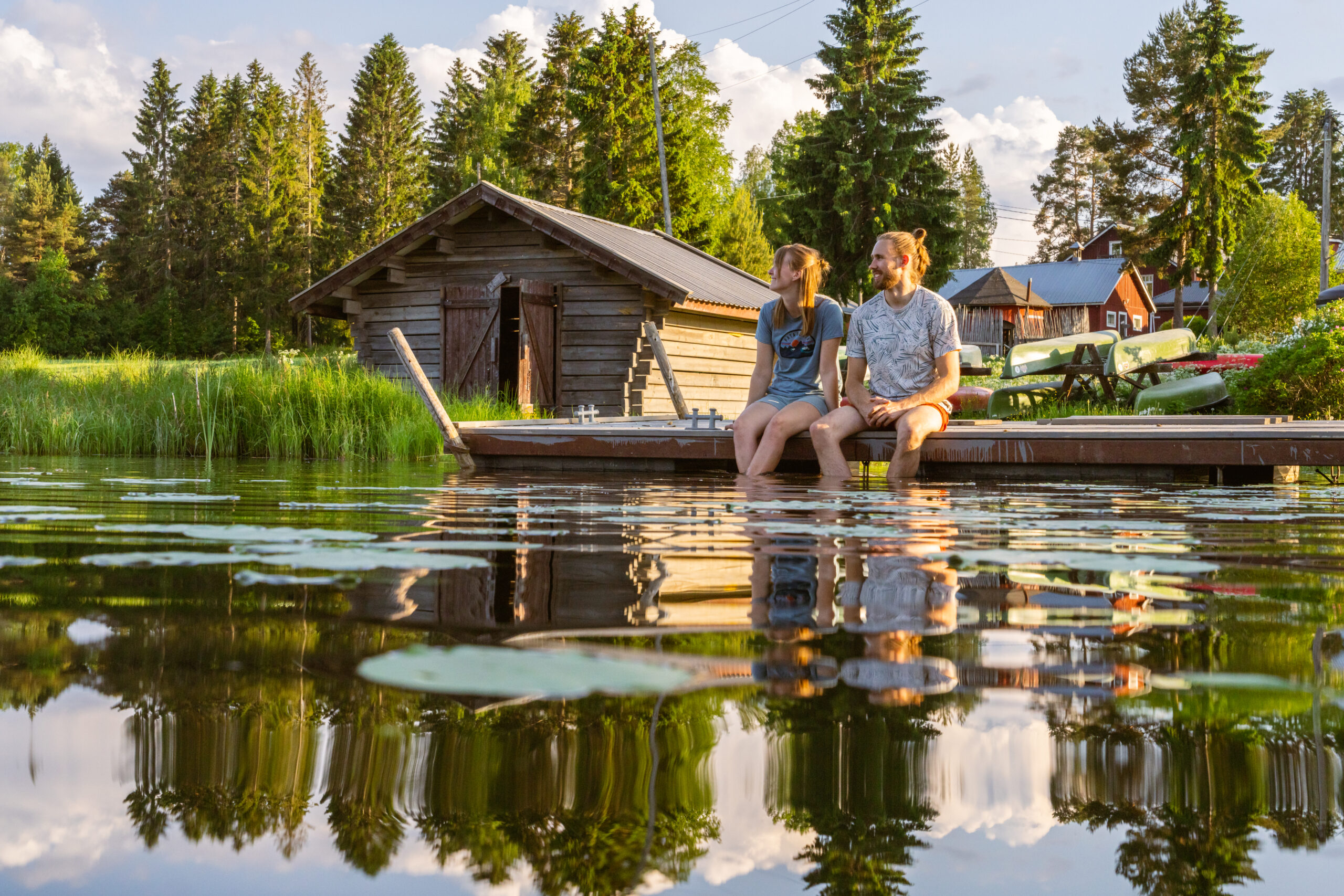 Pariskunta laiturilla istumassa nauttien kesästä